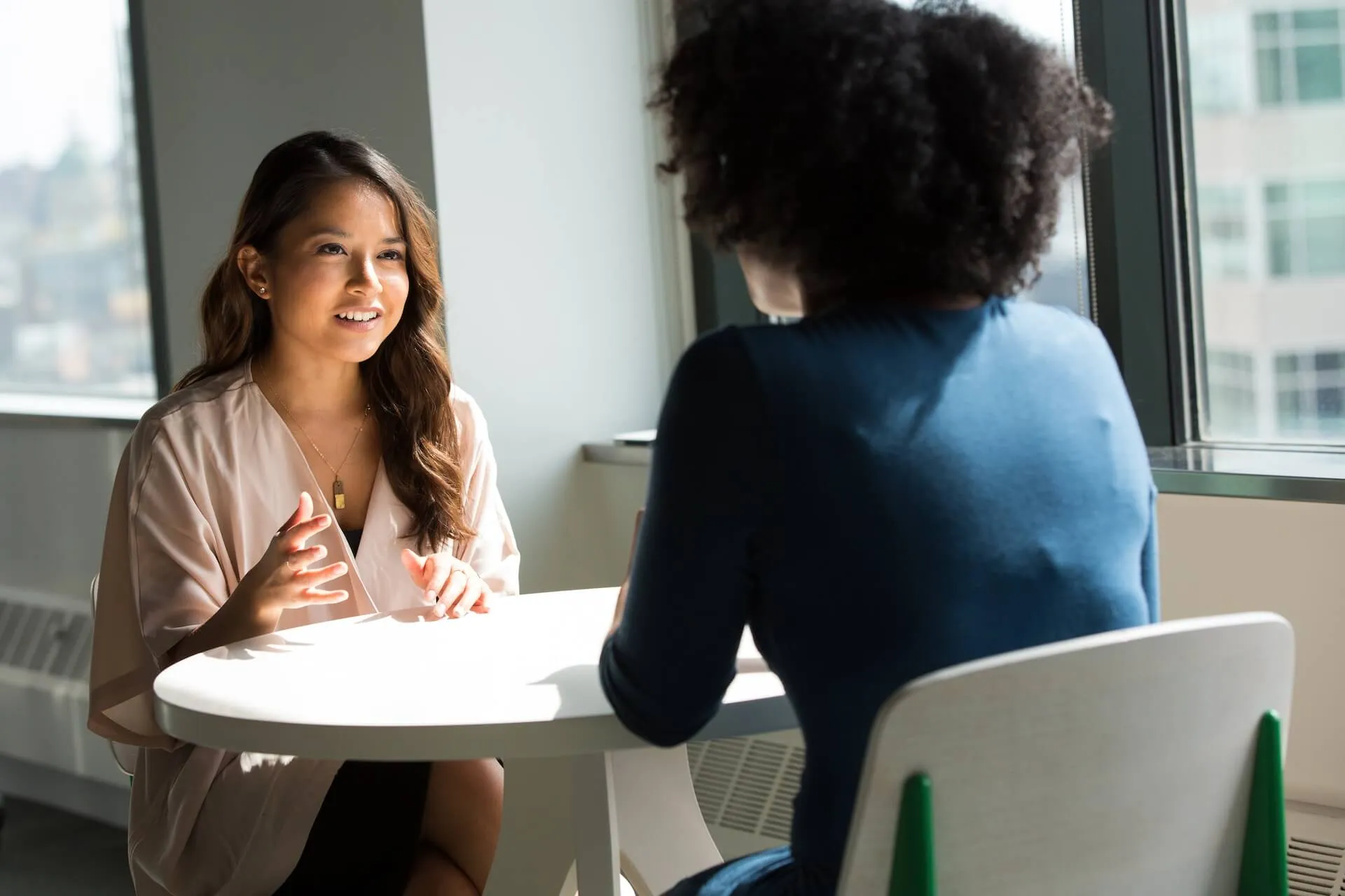 two women networking over a white table